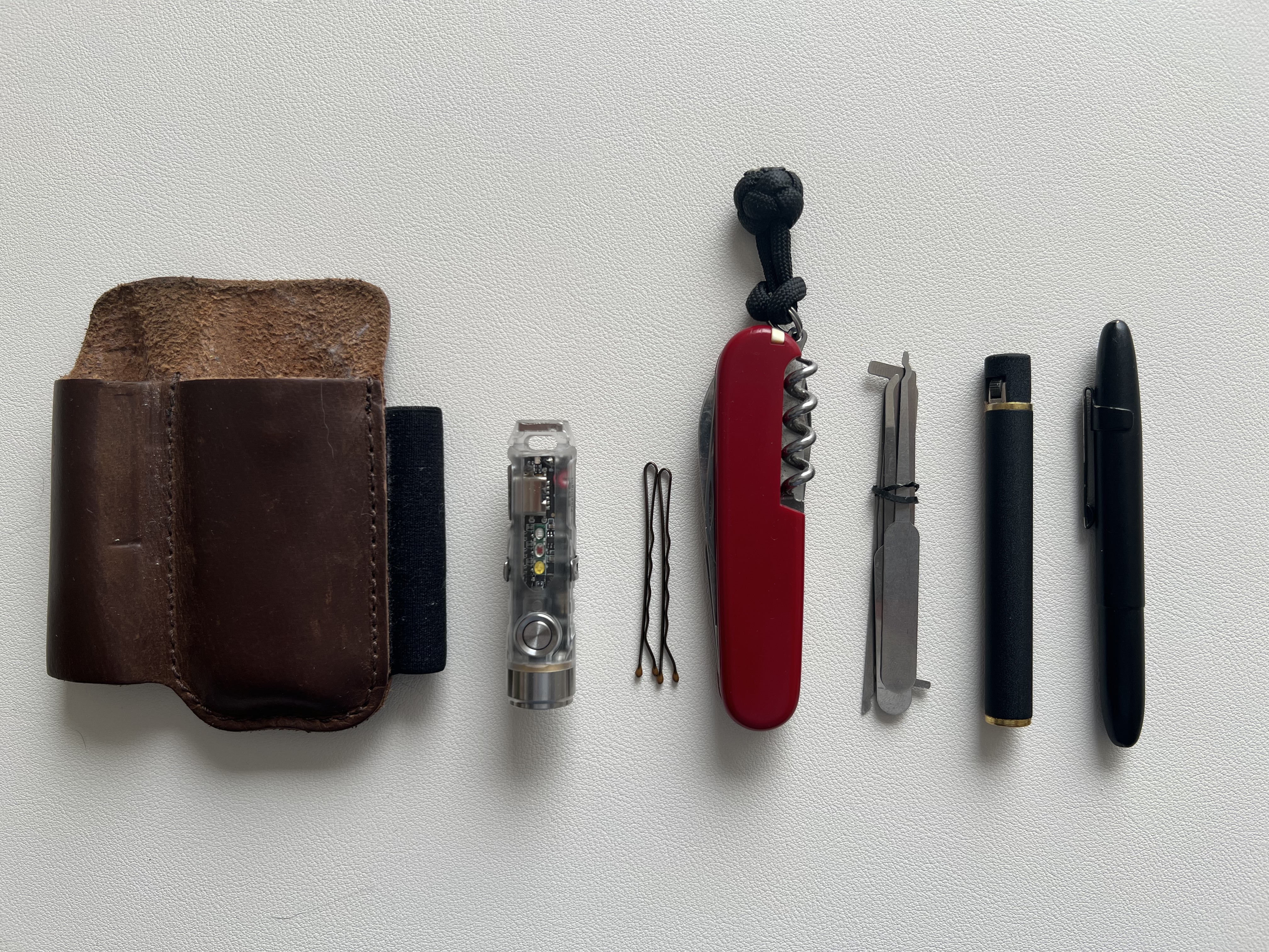 an image of a victorinox, a flashlight, a pen, and a lighter